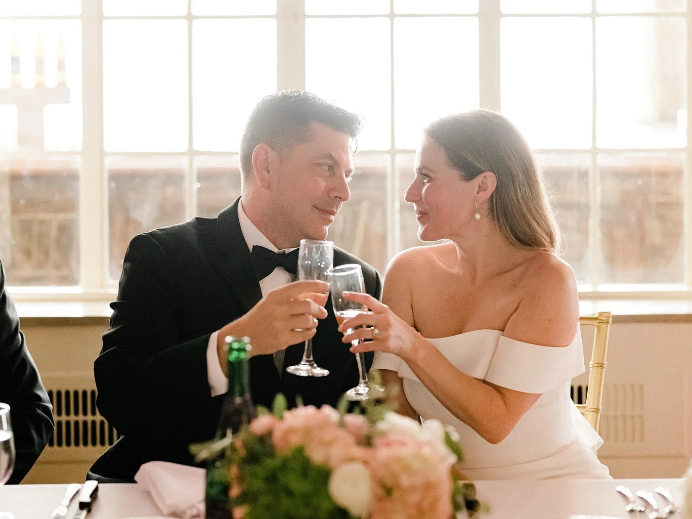 Bride and groom toasting with champagne at their reception table